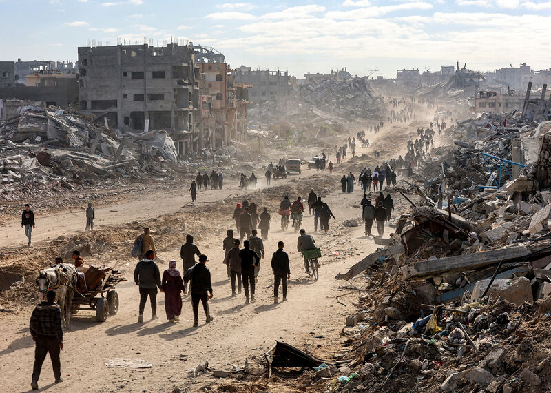 Personas caminan entre escombros en Yabalia, en el norte de la Franja de Gaza