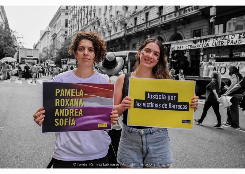 Dos personas con carteles de colores en los que piden justicia para Pamela, Roxana, Andrea y Sofía.