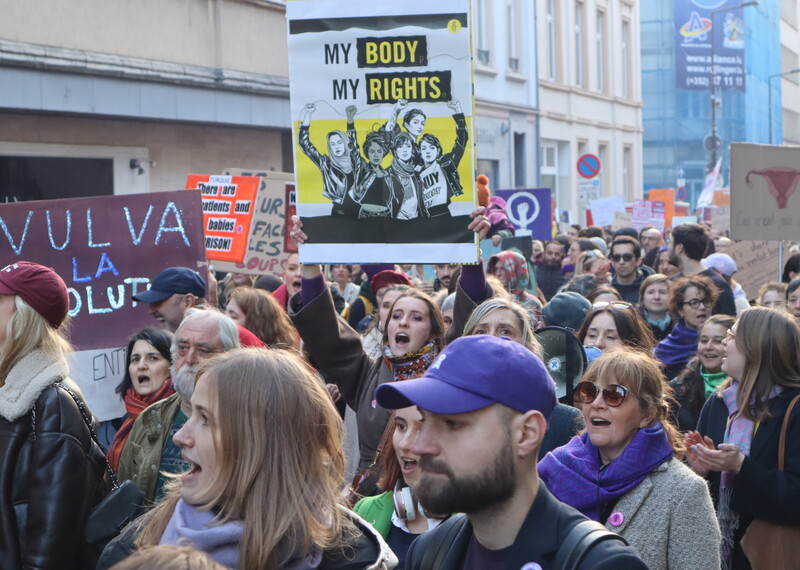 Un grupo de personas marcha en una calle con carteles que dicen “Mi cuerpo, mis derechos”.